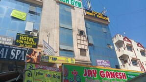 A building with multiple signs, including 'CRUNCH GYM', 'HOTEL BHAVY MANSION', and 'JAY GANESH'.