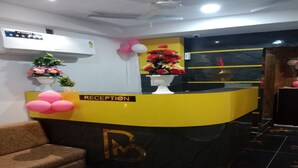 A reception desk with a yellow and black color scheme, a 'RECEPTION' sign, and a logo.