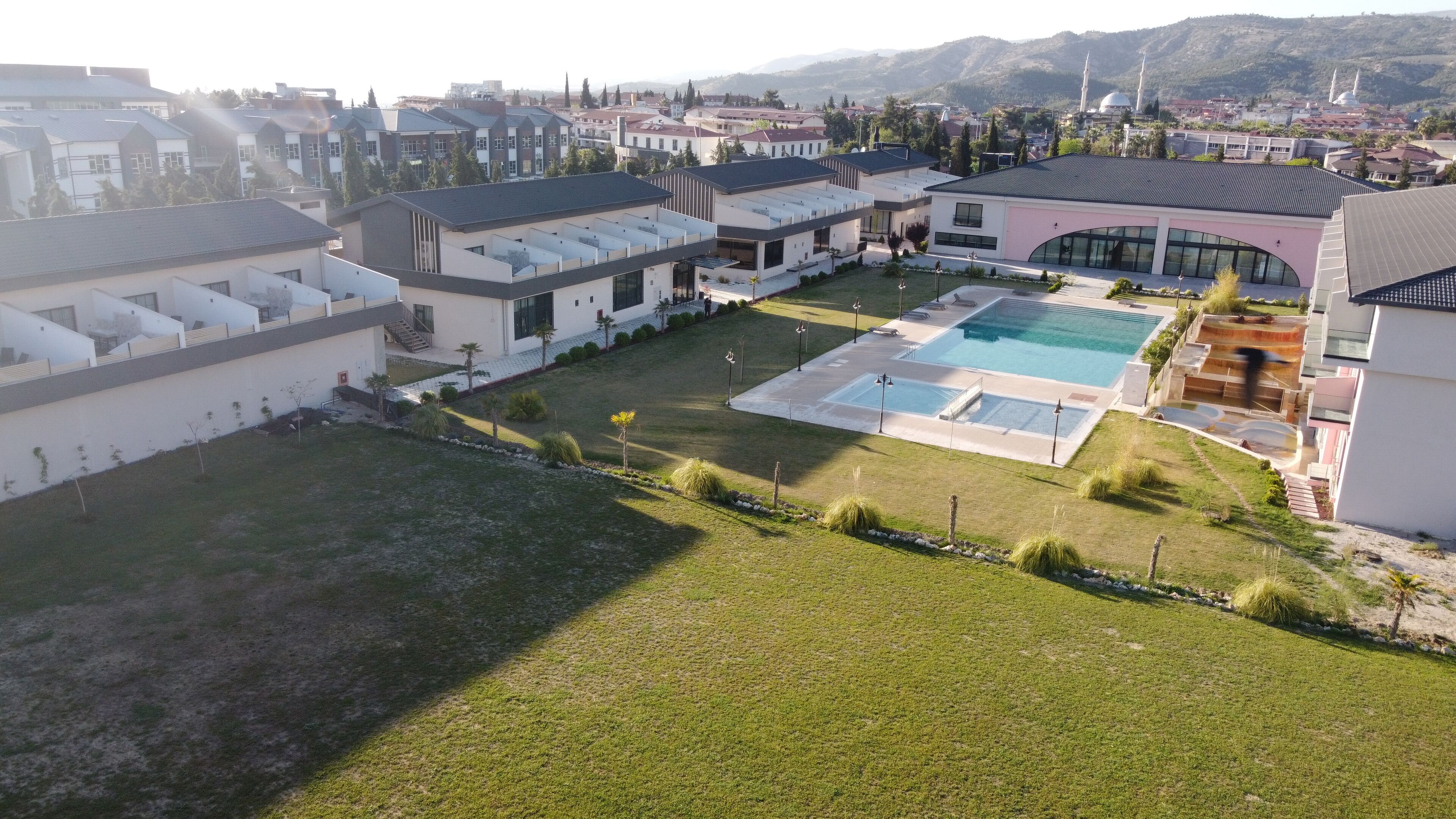 Zona residencial con casas modernas, una piscina y una mezquita al fondo.