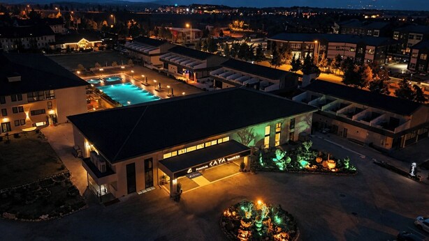 Un hotel con piscina, area esterna coperta e giardino curato.