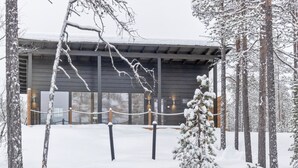 A snow-covered building with a modern architectural design, surrounded by snow-laden trees.