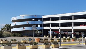 A multi-level parking garage with directional signs and potted plants.