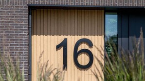 Un bâtiment sur lequel est affiché un grand chiffre « 16 » sur un panneau en bois.