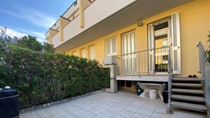 A residential building with a tiled patio, a covered outdoor seating area, and a staircase leading to the entrance. - Holiday home Leonida sea front close to the mountain, Marina di Carrara downtown (Marina di Carrara)