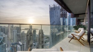 A high-rise building with a glass balcony overlooking a cityscape and water. - Luxury 3BR at Marina Gate | Stunning Sea Views, Pool, Gym & Prime Location (Marina)