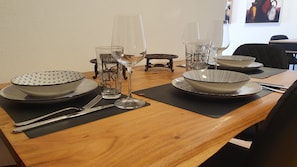 A beautifully set table awaits, complete with fine china, crystal glasses, and elegant silverware.
