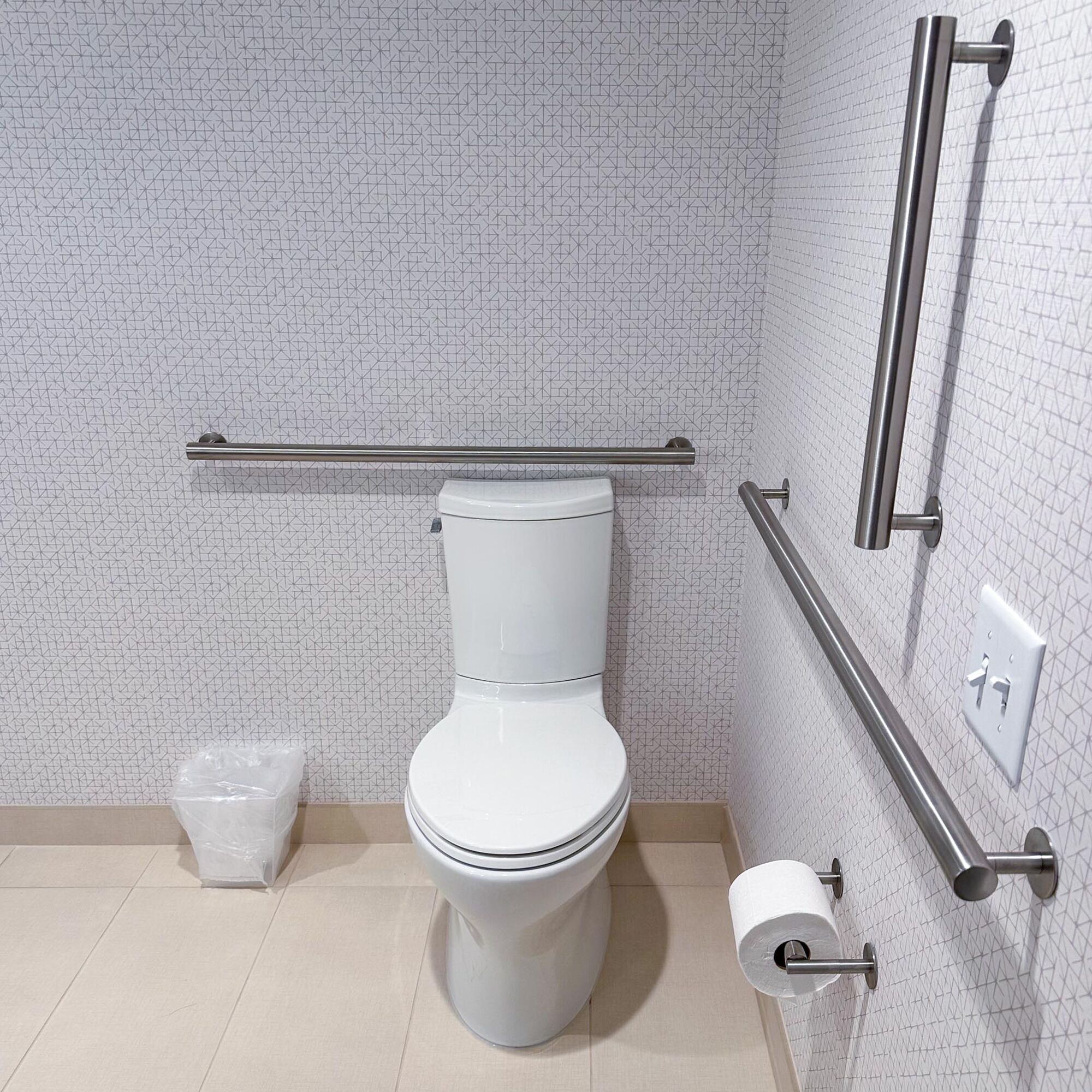 Un bagno moderno con il water bianco, un cestino e un porta carta igienica.