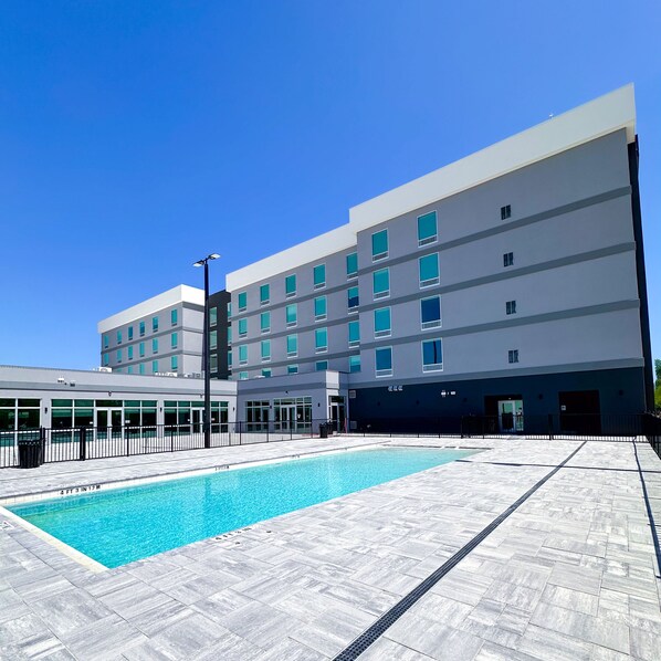 Un hôtel moderne doté d’une piscine, de plusieurs étages et d’un toit plat.