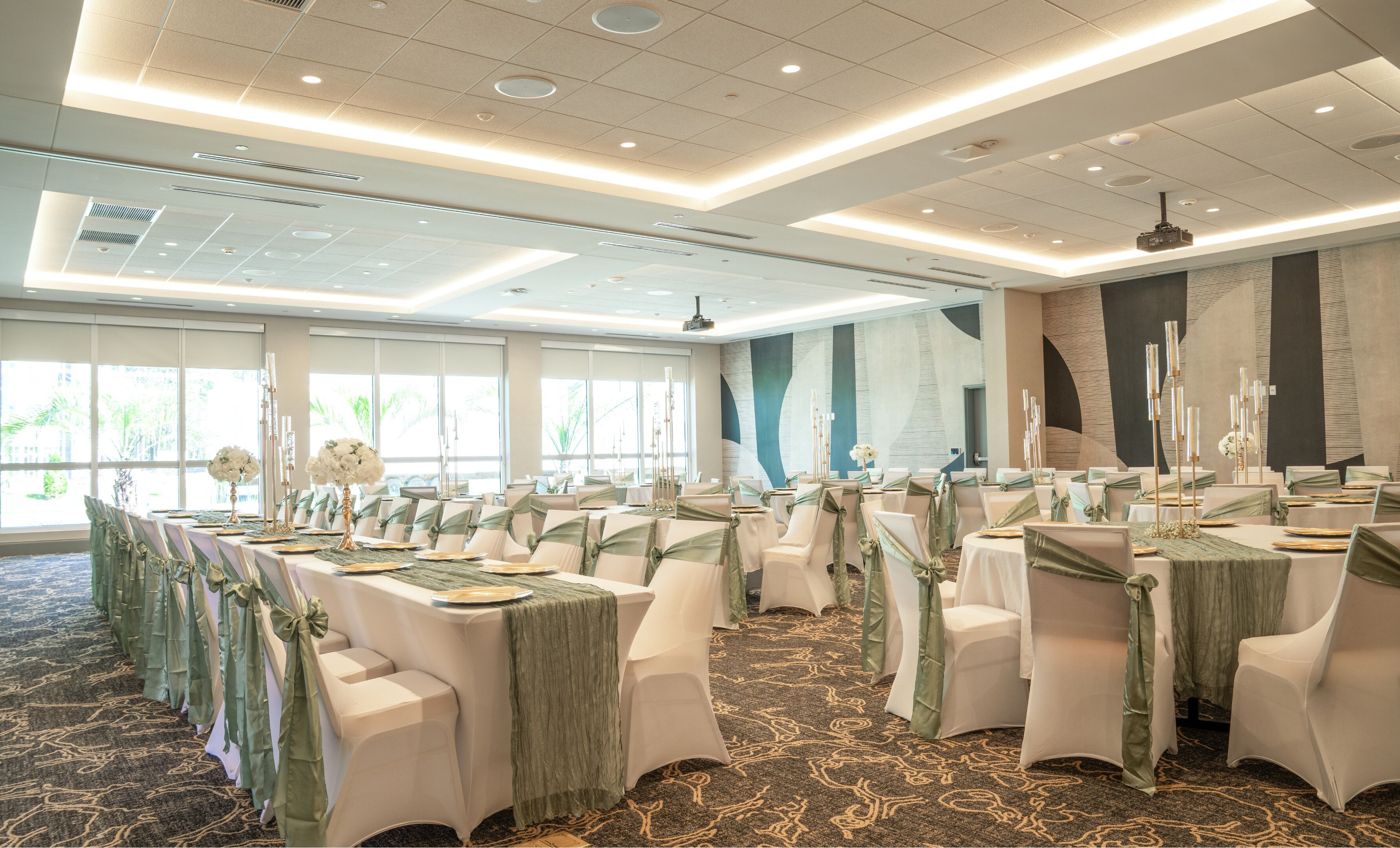 A banquet hall with rows of tables, each with white tablecloths and chairs, set for a formal event.