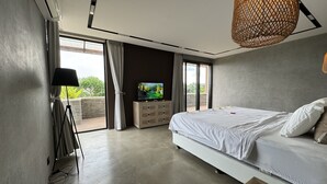 A modern bedroom with a large bed, a TV on a wooden cabinet, and a balcony with curtains. - Ocean view 2-bedrooms Yudistira villa 50m from the beach (Bali)