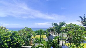 A view of a tropical resort with lush greenery and a clear view of the ocean. - Ocean view 2-bedrooms Yudistira villa 50m from the beach (Bali)