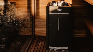 Una sauna con interior de madera, un banco y un armario de sauna con el nombre de la marca visible.