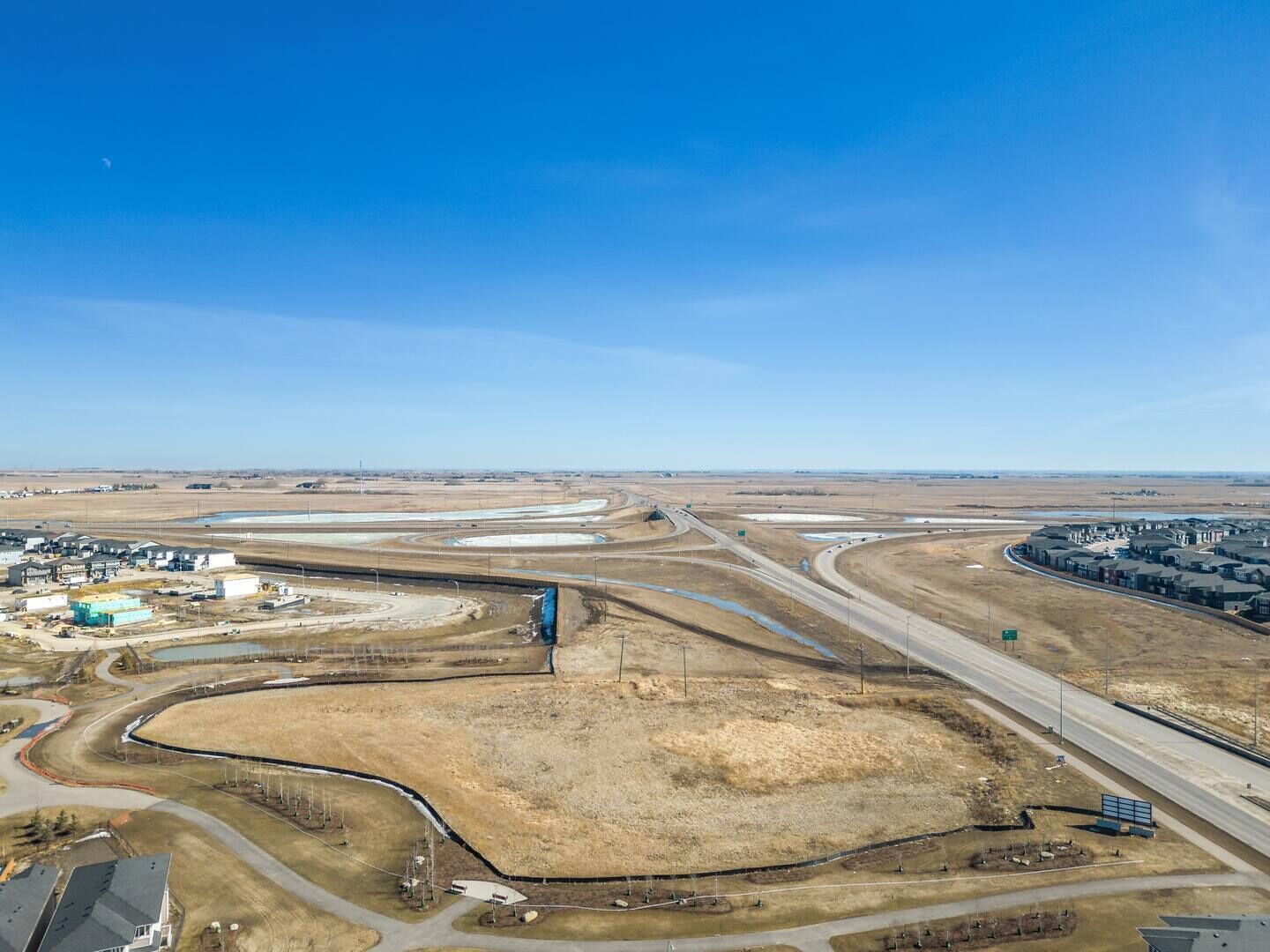 Ein Luftbild eines großen Industrieareals mit mehreren Gebäuden, Straßen und freien Flächen.