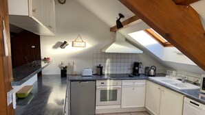 A kitchen with a dishwasher, a sink, a stove, and a microwave. - Bel appartement duplex, terrasse , 2 min du lac ,4pers (Sévrier)
