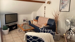A living room with a television, sofa, coffee table, and decorative items. - Bel appartement duplex, terrasse , 2 min du lac ,4pers (Sévrier)