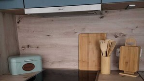 Une cuisine dotée d’un plan de travail en bois, d’un grille-pain, de planches à découper en bois et d’un porte-ustensiles.