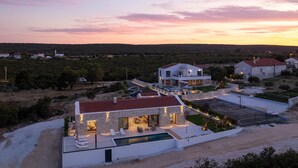 Une maison moderne dotée d’une piscine, d’un espace extérieur aménagé et offrant une vue sur le paysage environnant.