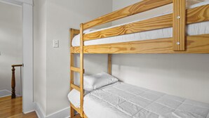 A bunk bed with white bedding in a room with white walls and wooden flooring. - House Patrick  4Bd Loft Style Parking (St. John's)