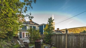 A backyard with a wooden deck, outdoor seating, and a chimney. - House Patrick  4Bd Loft Style Parking (St. John's)