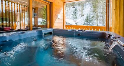 Chalet en pleine nature au bord d'un ruisseau avec vue sur les montagnes.