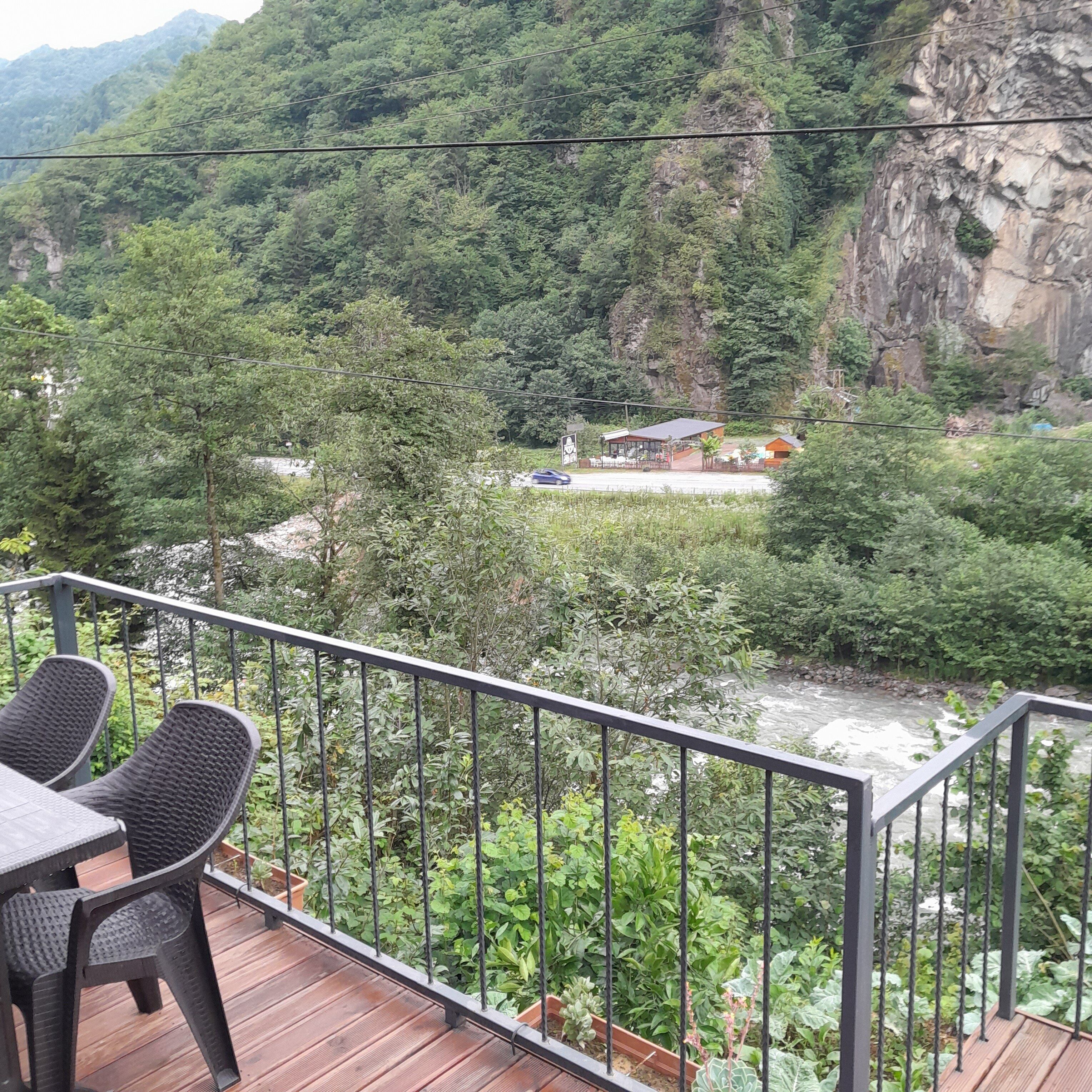 Un balcón con vista a un río y una montaña.