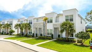 A row of modern, two-story townhouses with stone accents, well-maintained lawns, and a clear sky. - Comfortable home Near Disney & Private Pool 17414 (Clermont)