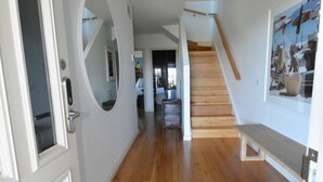 A hallway with wooden flooring, white walls, a staircase, and a bench. - Bayview Apartment Sorrento, a family-friendly haven 350 meters from the beach.   (Sorrento)