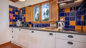 A kitchen with white cabinets, a window, and a tiled backsplash.