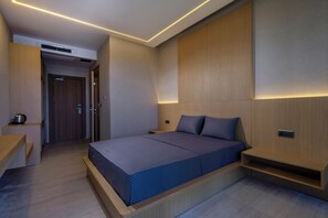 Ein modernes Schlafzimmer mit Bett, Nachttischen und eingebauten Stauraumlösungen.