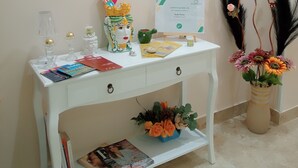 A white desk with a certificate, a vase with flowers, and a framed picture on the wall. - Rome Suite. Within walking distance of the sea, and the heart of beautiful Cefalù.  (Cefalù)