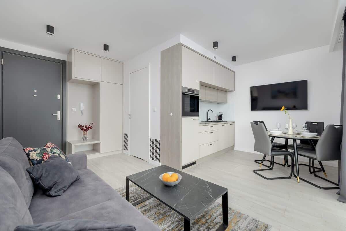 A modern apartment with a living room, dining area, and kitchen.