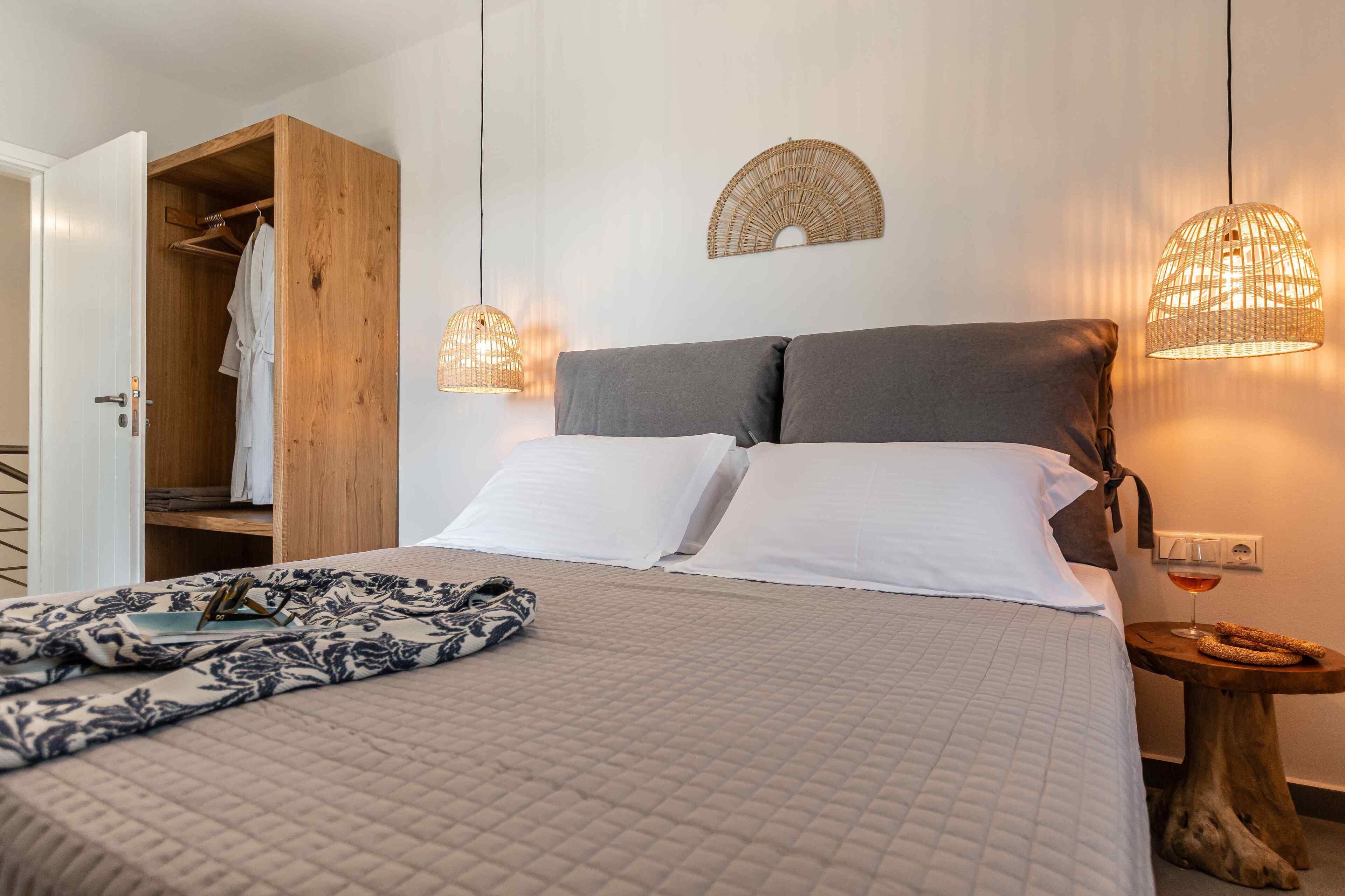 Une chambre à coucher avec un lit, une table de chevet et une armoire en bois.