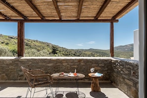 A terrace with a table set for two, overlooking a mountainous landscape. - Ktima Drilli Naxos (Naxos)