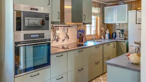 A modern kitchen with stainless steel appliances, a built-in oven, and a sink.