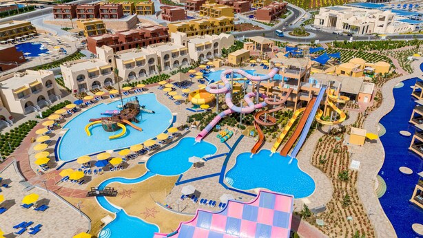 Un complexe hôtelier doté de plusieurs piscines, de toboggans aquatiques et de chaises longues.