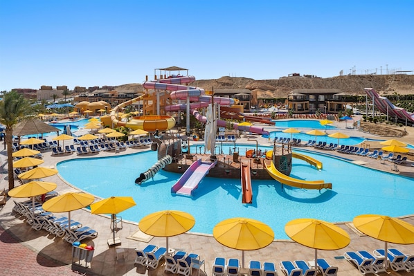 A resort pool area with multiple slides and sun loungers.