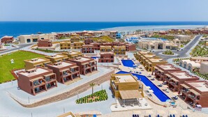 Un complexe hôtelier comprenant plusieurs bâtiments, une piscine et offrant une vue sur l’océan.