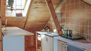 Una cocina con vigas de madera, tragaluces y servicios básicos.