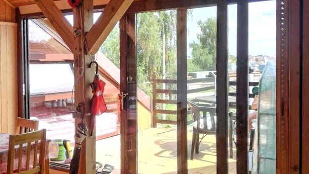 Interior de madera con una puerta corredera de vidrio que da a un patio exterior.