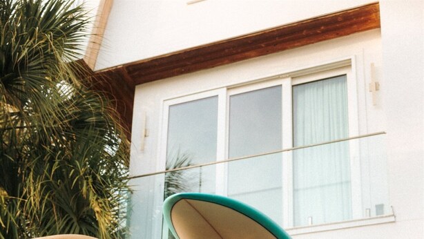 A person leaning out of a vehicle's open door, holding a surfboard. - Luxe Living: Private Heated Pool, STEPS to the beach (Jacksonville Beach)