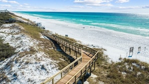 A beach with a wooden boardwalk leading to the shore.