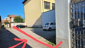 Une rue étroite avec une voiture blanche garée sur le bord.