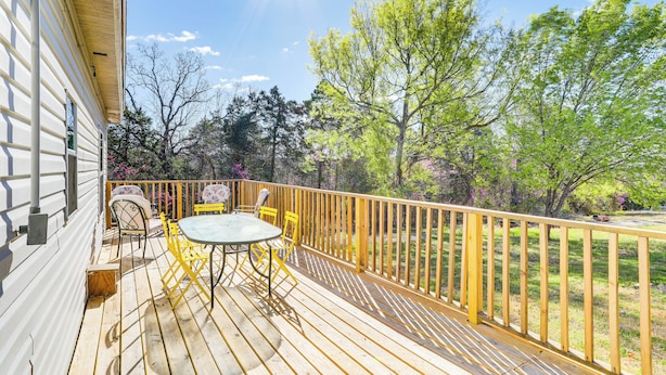 A wooden deck with a table and chairs, a railing, and trees in the background. - Arkansas Cabin w/ Deck < 1 Mi to Norfork Lake (Henderson)