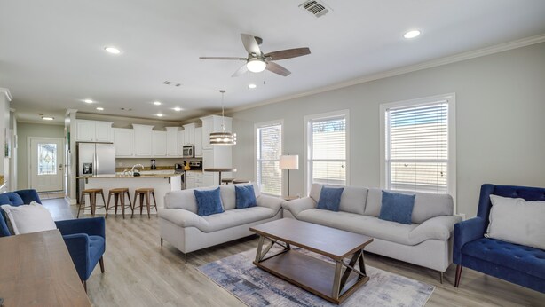 A modern living room with a sofa set, a coffee table, and a dining area.