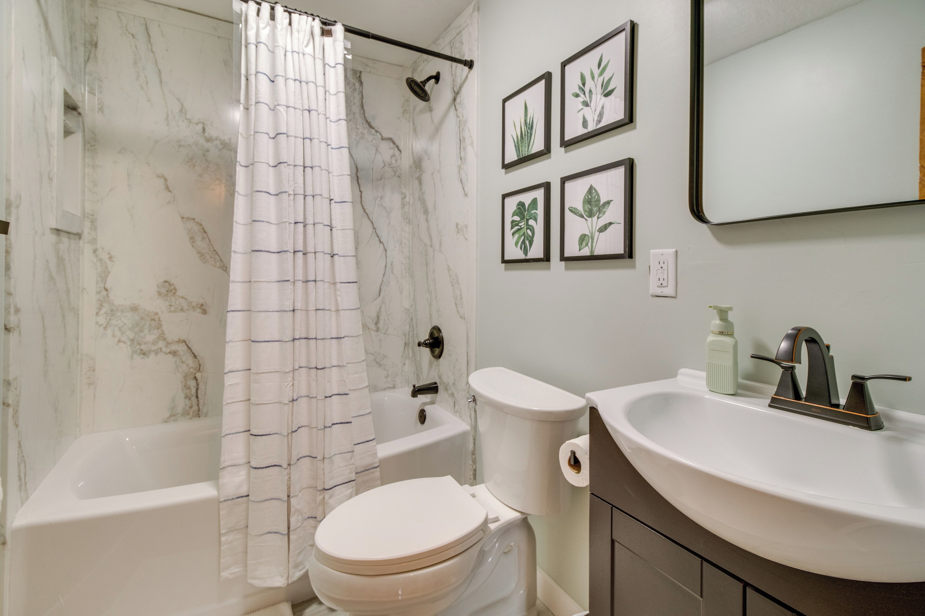 A bathroom with a bathtub, toilet, and sink.
