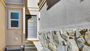A stone wall and a door with a wreath. - Modern Townhome w/ Hot Tub: 10 Mi to Snowbird! (Salt Lake City)