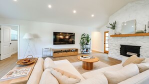 A modern living room with a sofa, coffee table, and fireplace. - Naples Duplex Home w/ Private Pool & Lanai! (Naples)