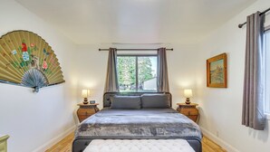 A bedroom with a bed, bedside tables, a fan, and a window. - Charming Arlington Home w/ Hot Tub & Fenced Yard! (Arlington)