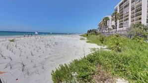 Una playa con un hotel al fondo.