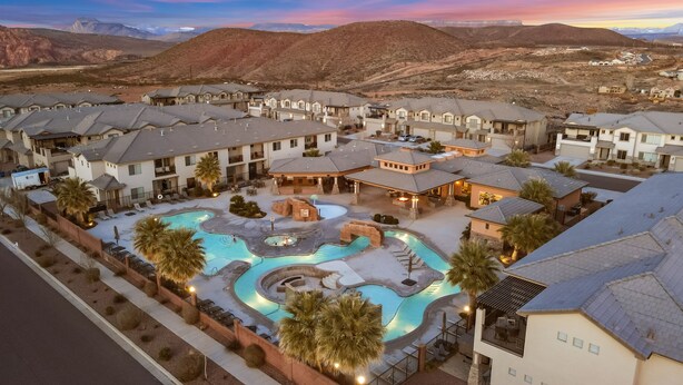 A residential area with multiple houses, a swimming pool, and a mountainous backdrop. - Zion's Paradise 6 Bedroom Townhouse (Hurricane)